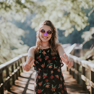 Woman using cool environmentally friendly and reef safe sunscreen on her nose and giving the peace sign